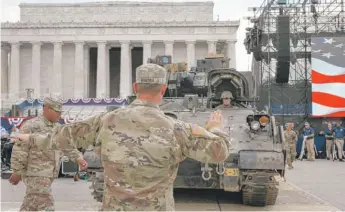  ?? JACQUELYN MARTIN/AP ?? Soldiers with the 3rd Infantry Division, 1st Battalion, 64th Armored Regiment, move a Bradley Fighting Vehicle into place by the Lincoln Memorial on Wednesday.