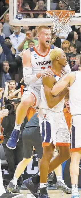  ??  ?? Mamadi Diakite (25) of Virginia celebrates with teammates after