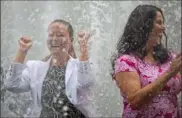  ??  ?? Eline de Graaf, Philips North America marketing executive, left, and Eleni Lucido, MSA Safety Inc. vice president and general manager, are engulfed by the spray.