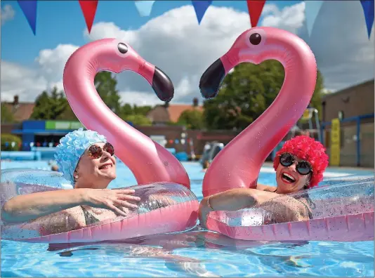  ??  ?? TESTING THE WATERS: Nicola Foster, left, and Jessica Walker brought along inflatable flamingos to enjoy a swim at Charlton Lido in London yesterday