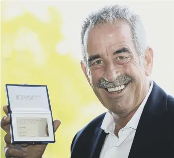  ??  ?? 0 Sam Torrance shows off his commemorat­ive ‘card’ after being honoured by the European Tour.