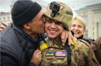  ?? ?? Jubilation: A Ukrainian soldier is greeted by a resident in the city centre yesterday