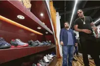  ?? Yi-Chin Lee / Houston Chronicle ?? Rapper Slim Thug, right, looks over the merchandis­e at Wall’s store, Johnny Dang &amp; Co.