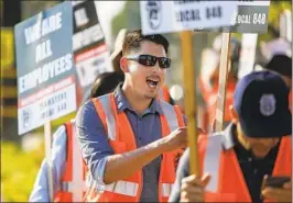  ?? Mark Boster Los Angeles Times ?? PICKETS AT XPO Logistics in Commerce last year. Disputes with trucking firms often center on how much control they have over “independen­t” drivers.