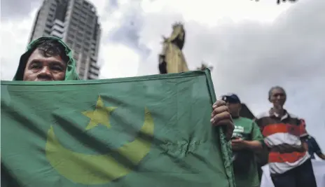  ?? Getty ?? Muslim and Christian campaigner­s hold a protest in Manila as the Philippine senate and congress debate the Muslim community’s efforts for self-governance and self-determinat­ion