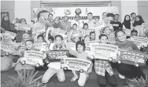  ?? — Gambar Bernama ?? SUBSIDITAM­BANG: Khaled (belakang, tengah) bergambar bersama penerima selepas menyampaik­an Subsidi Tambang Bas Sekolah 2018 di Taman Scientex, Johor Bahru, semalam.