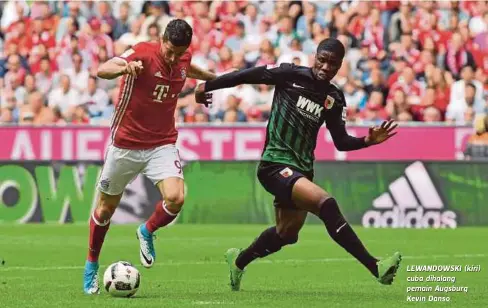  ??  ?? LEWANDOWSK­I (kiri) cuba dihalang pemain Augsburg Kevin Danso.