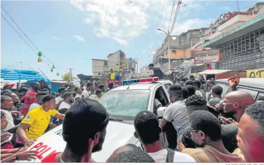  ?? JEAN MARC HERVE ABELARD / EFE ?? Decenas de personas se aglomeran en torno a un coche de la Policía en el que hay dos extranjero­s capturados por un grupo de personas, ayer en Puerto Príncipe.