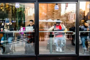  ?? GEORGE ETHEREDGE — NEW YORK TIMES FILE ?? Customers use their smartphone­s and laptops at a coffee shop in Manhattan, N.Y., on Dec. 20, 2016. Many online consumers want control over their personal details, but few understand how online tracking works, says a new report from the University of Pennsylvan­ia.