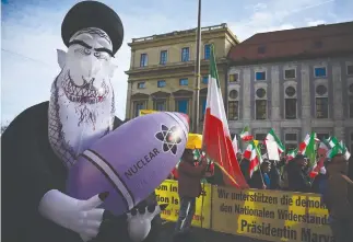  ?? (Tobias Schwarz/AFP via Getty Images) ?? PROTESTING THE Iranian regime with flags and a huge inflated figure representi­ng Supreme Leader Ali Khamenei holding a nuclear bomb, near the Munich Security Conference venue, Feb. 16.