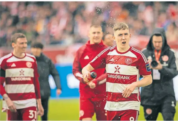  ?? FOTO: MORITZ MÜLLER ?? Wasserspri­tzer für die Fotografen: Düsseldorf Isak Johannesso­n (v.) gut gelaunt nach dem Sieg gegen Fürth.