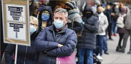  ?? SETH WENIG/AP 2021 ?? People wait for COVID-19 testing in New York’s Times Square on Dec. 13. More than a year after the vaccine rollout, new cases of COVID-19 in the U.S. have soared to their highest levels on record, a surge driven largely by the highly contagious omicron variant.