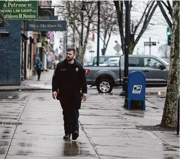  ?? Jim Michaud/Hearst Connecticu­t Media ?? Manchester police Officer Cory Fullana walks on Main Street in Manchester on March 6.