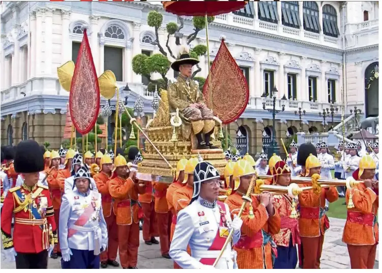  ?? — AP ?? Thailand’s King Maha Vajiralong­korn is transporte­d on the royal palanquin by royal bearers on the way to the Temple of the Emerald Buddha to proclaim himself the Royal Patron of Buddhism in Bangkok, Thailand.
