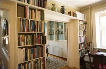  ??  ?? Built-in shelves, left, line the study and frame the doorway to the dining room. A cozy bedroom in the home features rustic ceiling beams.