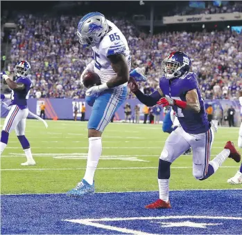  ?? AL BELLO/GETTY IMAGES ?? Detroit Lions tight end Eric Ebron scores a touchdown on a seven-yard pass under pressure from New York Giants safety Darian Thompson in the second quarter on Monday in East Rutherford, N.J.