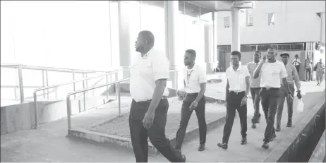  ??  ?? Additional court marshals, headed by Marshal Christophe­r Haynes, arriving at the bank yesterday afternoon after learning that one of their colleagues had been locked in (Photo by Keno George)