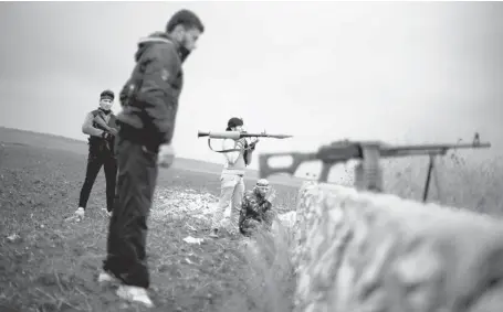  ?? MANU BRABO/THE ASSOCIATED PRESS FILES ?? Fighters of the Free Syrian Army, Syria’s main Western-backed opposition group, take their positions close to a military base, near the town of Azaz. On Friday, a ceasefire ended fighting near the Turkish border between the mainstream rebels and...