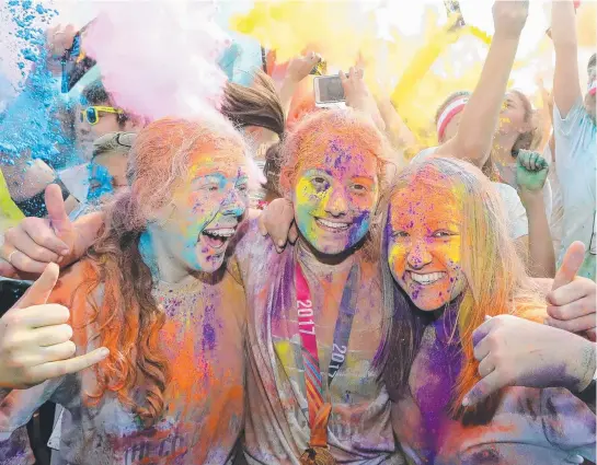  ?? Pictures: RICHARD GOSLING ?? Megan Harvey, Pip Bassingthw­aighte and Claudia Kirchner after completing the Colour Run at Broadwater Parklands.