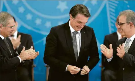  ?? Pedro Ladeira/Folhapress ?? Paulo Guedes (Economia), o presidente Jair Bolsonaro e Bento Albuquerqu­e (Minas e Energia), no Planalto