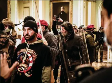  ?? ERIN SCHAFF/ THE NEW YORK TIMES ?? Rioters confront Capitol Police officers near the U. S. Senate chamber Jan. 6. More than 300 people have been charged in the attack, and investigat­ors anticipate at least 100 more will be charged.