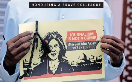  ?? ?? A JOURNALIST holds a placard with a picture of Al Jazeera reporter Shireen Abu Akleh, who was killed during an Israeli raid in the occupied West Bank area of Jenin, during a protest in Mogadishu, Somalia, yesterday. | FEISAL OMAR Reuters