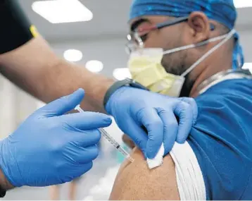  ?? LYNNE SLADKY/AP ?? A healthcare worker receives a Pfizer COVID-19 booster shot at Jackson Memorial Hospital Oct. 5 in Miami.