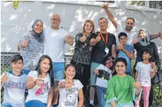  ?? FOTOS: MÜSSIGMANN ?? Glücklich über ihren Neuanfang in Deutschlan­d: Die Familie von Mohamed Bdewi (14, links), Kodrat Alawy (hinten rechts, 30) und weitere Syrer, die vor rund zweieinhal­b Jahren in Ravensburg ankamen.