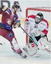  ?? Peter Schneider/the Associated Press ?? Geneva’s Alexandre Picard pokes at the puck at Canadian goalie Allen York Monday.