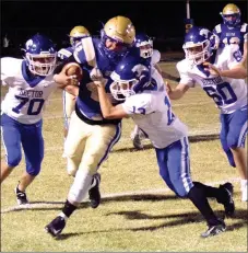  ?? Westside Eagle Observer/MIKE ECKELS ?? Bulldog quarterbac­k Brandon Montano (32, center) tries an endaround move to shake off a pack of angry Wildcats during the fourth quarter of the Decatur-Hector football contest in Decatur Friday night. Montano managed to gain enough yards to get a Bulldog first down.