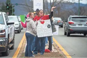  ??  ?? Amanda Scarbery waves to passing drivers while demonstrat­ing with other teachers along Route 60 across from the capitol building in Charleston, W.Va., on Monday.