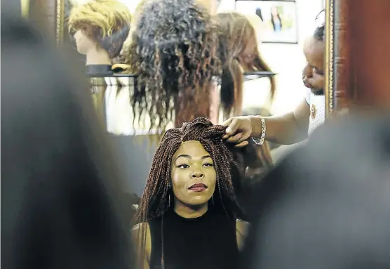  ?? Picture: MOELETSI MABE ?? LOCKSMITH: Patrick Missile, a wig designer and hairstylis­t based in Centurion, tends to a customer. He designs wigs for celebritie­s, both men and women