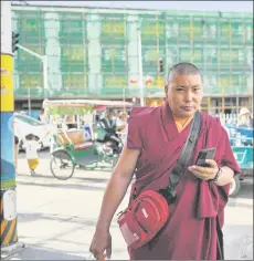  ??  ?? A Buddhist monk walking near a building being remodelled in the regional capital Lhasa in China’s Tibet Autonomous Region.