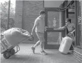  ?? COURANT FILE PHOTO ?? Noah Levine moves in to John Buckley Residence Hall with the help of his parents, Michael and Melissa Levine, last August. Uconn students arrive on campus later this month.