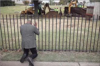  ?? Mike Simons / Associated Press ?? The Rev. Robert Turner, with Vernon A.M.E Church, prays as crews work on a second test excavation and core sampling on Tuesday as the search for remains at Oaklawn Cemetery in Tulsa, Okla., from the 1921 Tulsa Race Massacre continues.