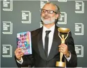  ?? ALBERTO PEZZALI/AP ?? Shehan Karunatila­ka holds the Booker Prize in London after the Oct. 17 announceme­nt of his win.