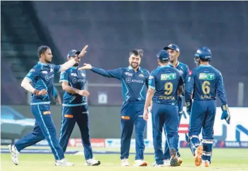  ?? Courtesy: IPL website ?? ↑
Gujarat Titans’ Rashid Khan (centre) celebrates with team-mates after taking the wicket of Lucknow Super Giants’ Jason Holder (unseen) during their IPL match in Pune on Tuesday.