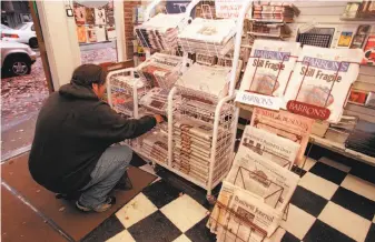  ?? Phil H. Webber ?? A shopper reaches to purchase a newspaper, something to be thankful for on this day.