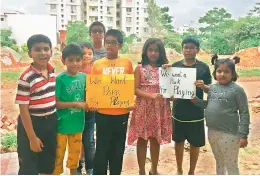  ??  ?? Children aged eight and 12 hold posters asking for the park to be returned so that they can play again. In the backdrop one can see building material dumped in the park.