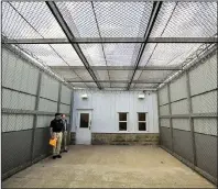  ?? Arkansas Democrat-Gazette/STATON BREIDENTHA­L ?? Pulaski County sheriff’s office Lt. Cody Burk and Lt. Derrick Freeman (left) look at one of the newly enclosed exercise areas at the Pulaski County jail on Friday in Little Rock.