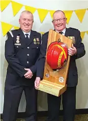  ?? ?? Drouin Fire Brigade captain Mark Fox congratula­tes John Atkins on his Outstandin­g Service Award.