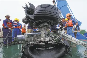  ?? Azwar Ipank / AFP / Getty Images ?? Workers secure a tire assembly recovered from the Lion Air jet that crashed after takeoff from Jakarta last Monday, killing all 189 people on board. The data recorder has been recovered.