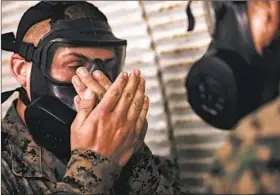  ??  ?? Recruit Gabriel Rector, 17, executes the drill of clearing his mask after it has filled with tear gas before being allowed to leave the “confidence chamber.”