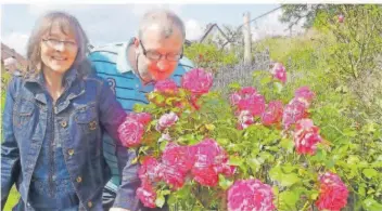  ?? FOTO: FRED KIEFER ?? Petra und Armin Klein an einem üppig blühenden Rosenstrau­ch in ihrem Garten in Lebach – auch der kann im Rahmen der Aktion „Das offene Gartentor“besucht werden.