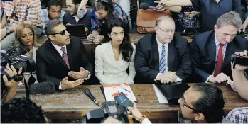  ?? AMR NABIL/THE ASSOCIATED PRESS ?? Members of the media surround Canadian journalist Mohamed Fahmy, left, his lawyer Amal Clooney, centre, and Canadian ambassador to Egypt Troy Lulashnyk, second from right, in a courtroom in Cairo on Saturday before Fahmy’s sentencing to three years in...