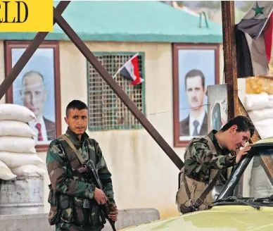  ?? AFP / GETTY IMAGES ?? Syrian soldiers man the Wafideen checkpoint on the outskirts of Damascus near the rebel-held Eastern Ghouta region on Tuesday during a “humanitari­an pause” to allow some of the people living in the rebel-held area to leave.