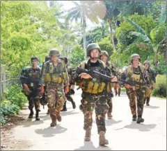  ?? STRINGER/AFP ?? Philippine soldiers walk along a highway after battling Abu Sayyaf militants on the southern island of Mindanao on August 26.