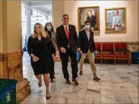  ?? ALYSSA POINTER/ ALYSSA. POINTER@ AJC. COM ?? Surrounded by his staff, Georgia Secretary of State Brad Raffensper­gerwalks back to his office after refusing to take questions following his remarks during a briefing at the Georgia State Capitol building Friday.