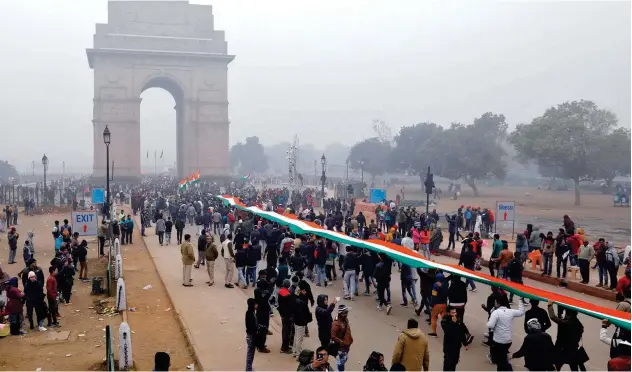  ?? Reuters ?? ↑ Demonstrat­ors hold a flag in front of India Gate during a rally against the new citizenshi­p law in New Delhi.