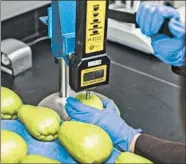  ??  ?? Top: Scientist Fang Tham, right, tests the firmness of a chayote with a durometer while senior post harvest Scientist Derik Jiwan records the data at Hazel Technologi­es in Chicago’s Bronzevill­e neighborho­od on Nov. 15. This measuremen­t helps determine the quality of the fruit.
Above: Tham measures the force needed to puncture a chayote with a penetromet­er, above.